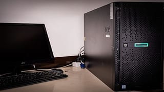 Serveur HPE en tour à côté d’un poste de travail